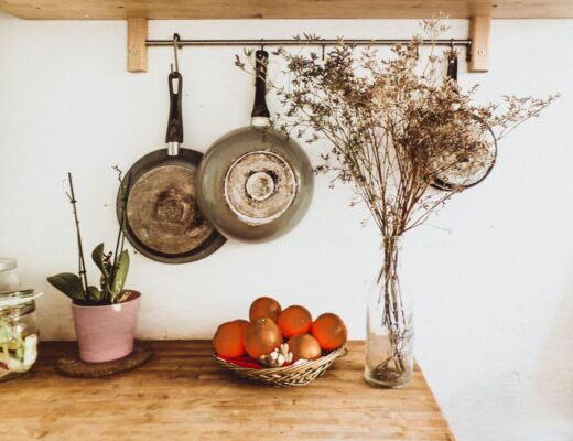 two gray frying pans hanging on wall