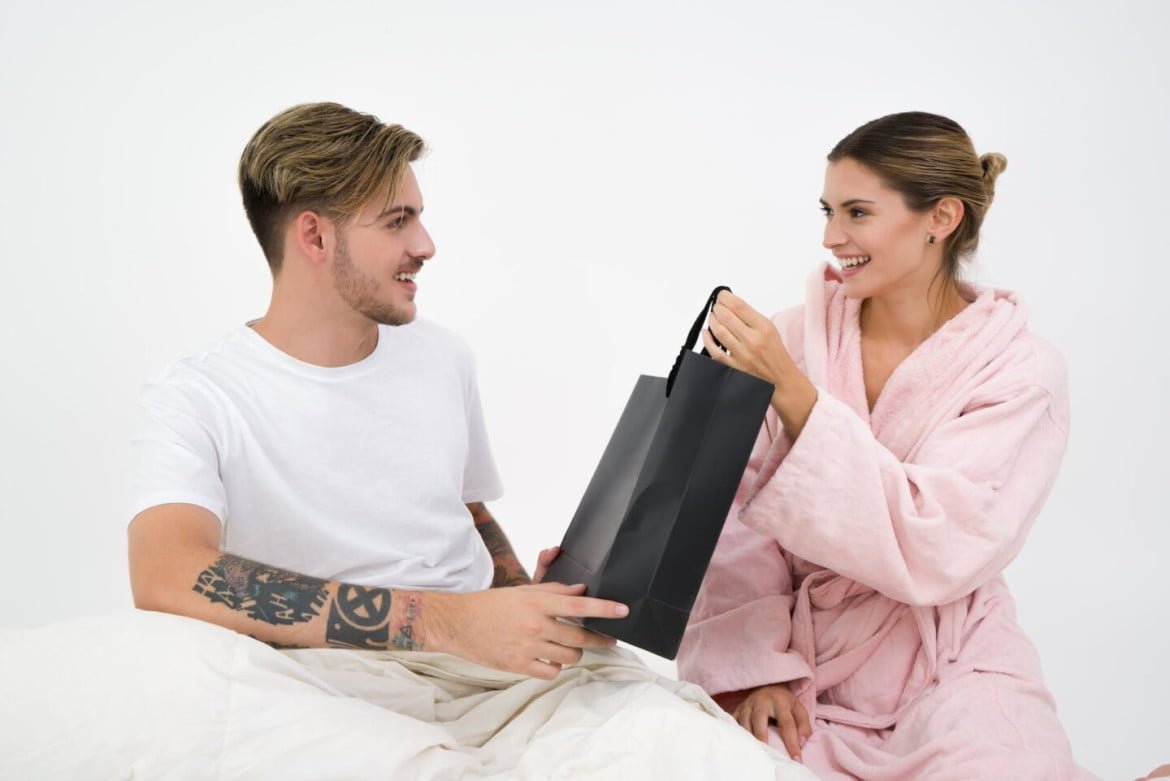 man and woman holding black tote bag